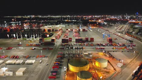 Drohnenansicht-Der-Long-Beach-Shipyard-Bei-Nacht-Mit-Hoch-Aufragenden-Kränen-Und-Reihen-Von-Frachtcontainern