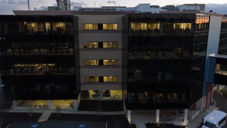 Aerial-push-in-shot-on-American-office-building-lit-up-at-night