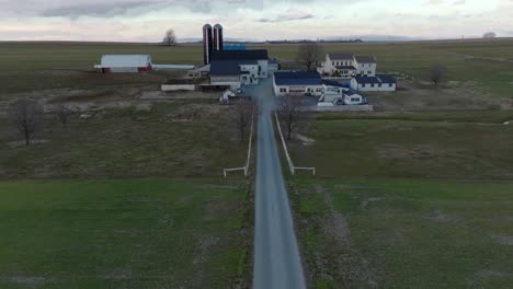 Aerial-flight-over-stone-driveway-path-towards-farm