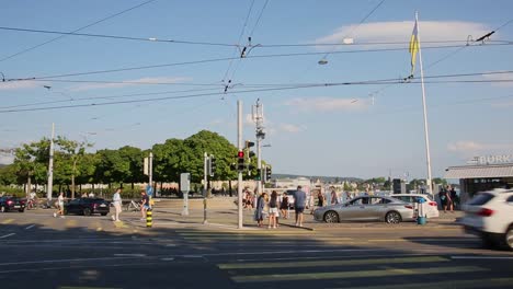 Calle-Concurrida-De-Zúrich-Con-Tráfico-Y-Peatones-Caminando-Por-El-Puerto-A-La-Luz-Del-Sol