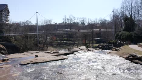 Aerial-flight-towards-Liberty-Bridge-with-water-fall-in-Greenville,-South-Carolina