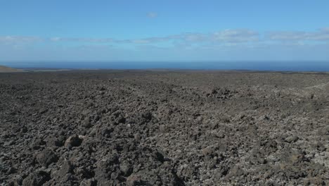 Smooth-aerial-view-flight-Volcano-lava-field-Lanzarote-Canary-Islands,-sunny-day-Spain-2023