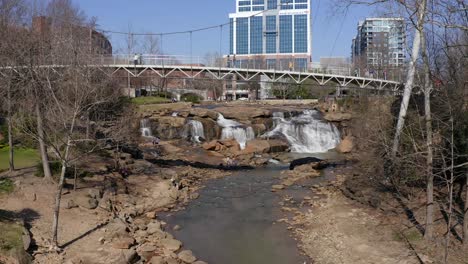 Low-aerial-rising-reveal-shot-of-Liberty-Bridge-and-tall-Bank-of-America-skyscraper-in-Greenville,-South-Carolina