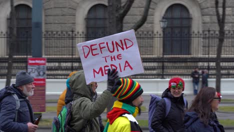 Hombre-Sosteniendo-Un-Cartel-De-Desembolso-De-Los-Medios-Durante-Las-Protestas-De-La-Corona