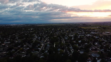 Aerial-landscape-view-over-a-suburban-green-area,-during-sunset
