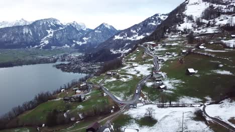 Aerial-push-in-flight-to-a-mountain-road-with-a-bus-driving-in-Switzerland