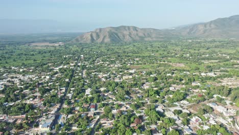Luftbild-über-Die-Ländliche-Stadt-Neiba-An-Sonnigen-Tagen-Und-Atemberaubende-Bergkette-Im-Hintergrund---Provinz-Baoruco,-Dominikanische-Republik