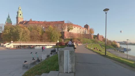 Pedestrian-traffic-on-Wisla-boulevard-by-Wawel-castle,-Krakow-Poland,-time-lapse