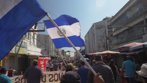 Salvadoran-flags-wave-during-a-peaceful-protest-in-the-city-streets-against-current-president-Nayib-Bukele---slow-motion
