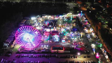 An-aerial-view-high-up-over-the-colorful-ferris-wheel-in-Santa's-Enchanted-Forest-and-street-fair