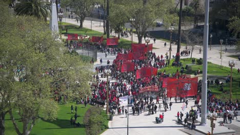 Protestors-against-government-are-walking-down-the-street-in-Buenos-Aires-and-holding-red-banners