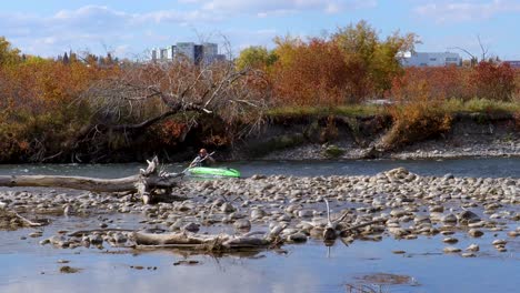 Navegar-En-Kayak-Por-Un-Río-Que-Fluye-Rápidamente-Con-Una-Ciudad-Al-Fondo