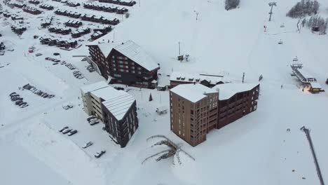 Hotel-Myrkdalen-Rodeado-De-Edificios-De-Apartamentos-Y-Pistas-De-Esquí-En-La-Mañana-De-Invierno---Vista-Aérea-Del-Hotel-A-Primera-Hora-De-La-Mañana-Nevada-Con-Remonte-En-Segundo-Plano