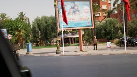 Driving-through-a-Marrakesh-Morocco-on-a-hot-sunny-day,-looking-outside-the-car-window