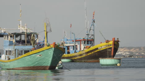 Person-walking-towards-his-fishing-boat-on-coastline-of-Vietnam,-handheld-view