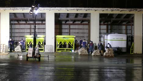 Workers-in-blue-clothing-work-together-to-fill-the-sandbags-needed-for-flood-control-measures,-Abbotsford,-BC,-Canada---static-shot