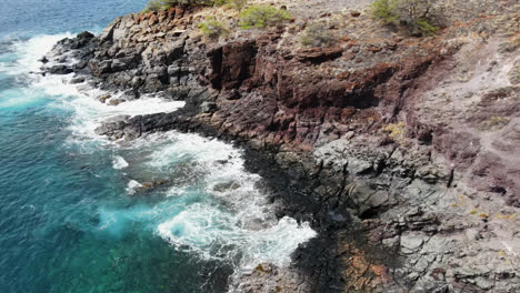 Drone-flying-down-the-coastline-of-the-West-Mountains-in-Maui,-Hawaii