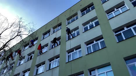 Escaladores-Limpian-Ventanas-Disfrazados-De-Dibujos-Animados-E-Historias-Infantiles-En-Un-Hospital-Infantil-En-Gdansk-En-La-Calle-Polanki