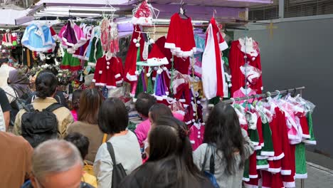 Fußgänger-Gehen-An-Einem-Straßenstand-Vorbei,-An-Dem-Weihnachtsartikel-Wie-Hüte,-Ornamente-Und-Kostüme-In-Hongkong-Verkauft-Werden