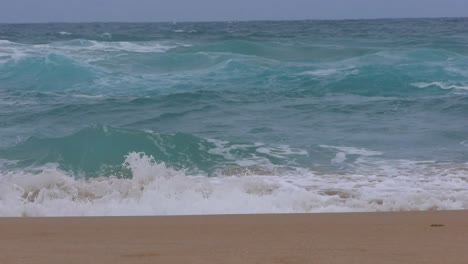 Slow-motion-wave-rolls-splashing-on-a-wild-sandy-beach-in-Australia