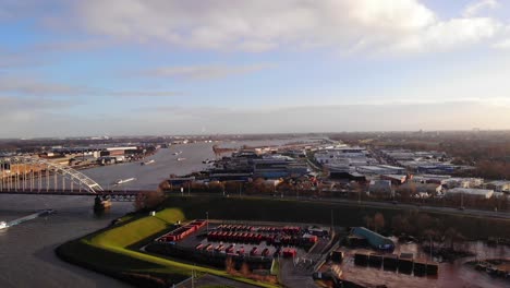 Aerial-View-Of-Bridge-over-the-Noord-With-Traffic-And-Ships-Going-Past-On-Sunny-Afternoon