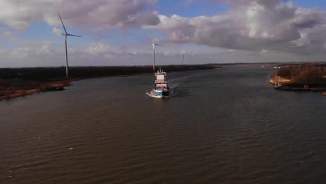 Antena-Sobre-Oude-Maas-Con-Carga-De-Saludo-Vista-En-La-Distancia-Y-Turbinas-Eólicas-Junto-A-La-Orilla-Del-Río