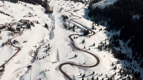 Dolly-forward-drone-shot-along-beautiful-winding-mountain-road-in-winter