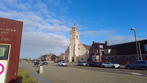 POV-Walking-Past-Information-Sign-Post-On-Pavement-Near-Andreas-Church-At-Katwijk-aan-zee