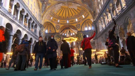 Touristen,-Die-Eine-Maske-Tragen,-Besuchen-Die-Große-Moschee-Der-Heiligen-Hagia-Sophia,-Offiziell-Bekannt-Als-Die-Große-Moschee-Der-Heiligen-Hagia-Sophia,-Und-Früher-Die-Kirche-Der-Hagia-Sophia-In-Der-Türkei-Istanbul-01-03-2022