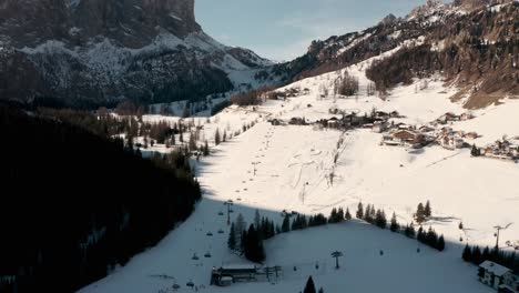 Low-drone-shot-towards-small-busy-ski-village