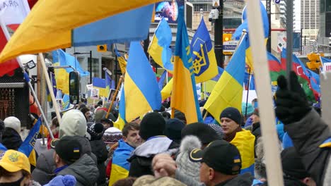 Crowd-of-People-Protesting-the-Russia-Invation-into-Ukraine,-Protesters-Holding-Ukrainian-Flags-in-Support---Steady-shot