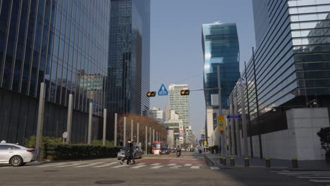 Calle-Con-Gente-Caminando-Y-Coches-Pasando-Entre-Las-Torres-De-Cristal-De-La-Sede-Central-De-Samsung-En-El-Distrito-De-Gangnam---Día-Estático