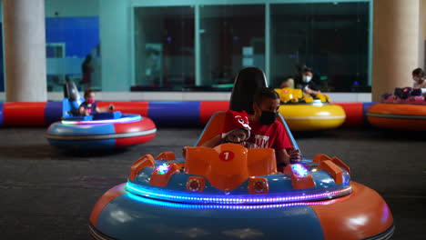 mechanical-game-with-children-playing,-bumping-into-each-other-in-play-area,-Bumper-Cars,-Inflatable-Bumper-Cars