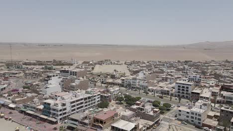 Aerial:-Small-Pacific-town-of-Paracas-Peru-in-endless-sandy-desert