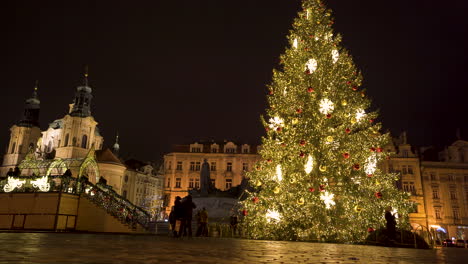 Gente-Caminando-Por-El-árbol-De-Navidad-Decorado-En-La-Plaza-De-La-Ciudad-Vieja,-Praga