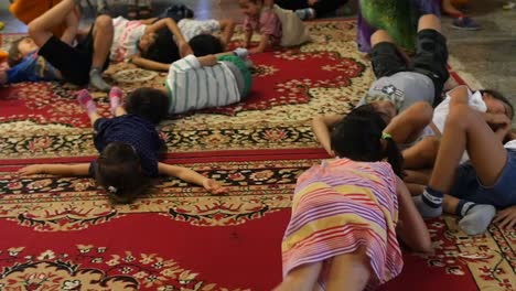 Asiatische-Kinder-Rollen-Herum-Und-Spielen-Auf-Einem-Schönen-Roten-Persischen-Teppich
