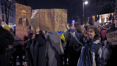 2022-Russia-invasion-of-Ukraine---protesters-holding-posters-with-Putin's-face-at-an-anti-war-demonstration-in-Warsaw-on-the-very-first-day-of-the-war