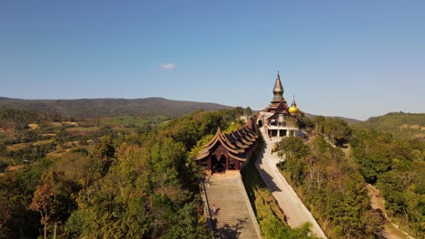 Imágenes-Aéreas-Hacia-El-Templo-Que-Revelan-Una-Entrada-Y-Gente-Subiendo-Y-Bajando-Las-Escaleras,-Wat-Somdet-Phu-Ruea,-Ming-Mueang,-Loei-En-Tailandia