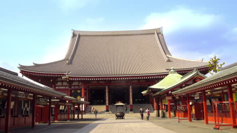 Asakusa,-Tokio,-Japón,-Alrededor-De-Abril-De-2020:-Tiendas-De-Fortuna-Y-Amuletos-Alineadas-A-Ambos-Lados-Del-Enfoque-Del-Templo-Tradicional-Japonés,-Donde-Los-Fieles-Caminan-En-Un-Tranquilo-Y-Soleado-Día-De-Primavera