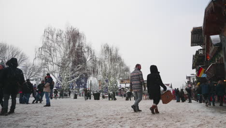 Static-shot-of-People-walking-on-a-road-covered-with-snow-on-a-winter-morning-in-Leavenworth,-WA