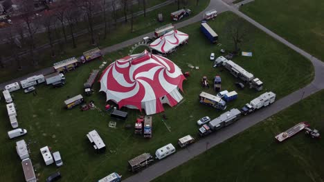 Planet-circus-daredevil-entertainment-colourful-swirl-tent-and-caravan-trailer-ring-aerial-view-high-up-zoom-in