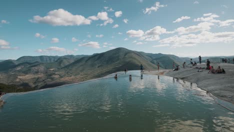 Tourists-enjoying-natural-springs-attraction,-Hierve-el-agua,-Oaxaca,-Mexico