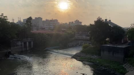 Orangefarbener-Sonnenuntergangshimmel-über-Der-Flusswasserstraße-Im-Stadtviertel-In-Dhaka,-Bangladesch