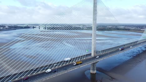 Mersey-gateway-landmark-aerial-view-above-toll-suspension-bridge-river-crossing-rising-tilt-down-left-shot