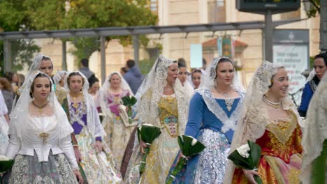 A-group-of-Spanish-women-wearing-traditional-dresses-walk-down-the-street-taking-part-in-the-Fallas-Ofrenda-festival-in-Valencia
