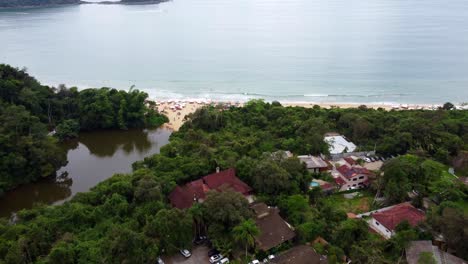 Aerial-flying-over-the-forest,-the-beach-and-the-sea-of-Ubatuba-on-sunny-day,-Brazil