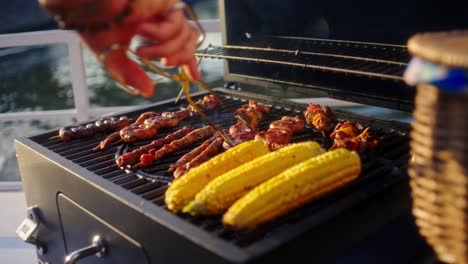Slow-motion-shot-of-a-A-hand-gently-turning-meat-sticks-and-corn-whilst-on-a-barbecue