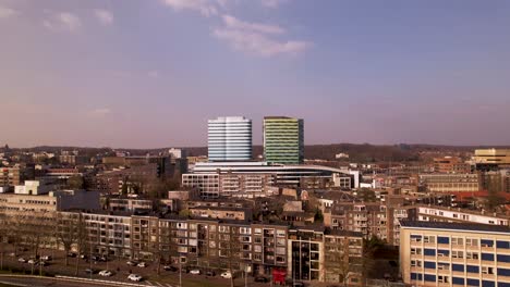 Antenne-Rückwärtsbewegung-Hochhaus-Zeitgenössische-Moderne-Architektur-Des-Zentralen-Bus--Und-Bahnhofs,-Der-Sich-über-Der-Stadt-Erhebt-Und-Den-Kreisverkehr-Enthüllt,-Der-Den-Fluss-Rijn-Im-Vordergrund-Kreuzt