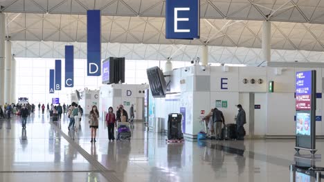 Passagiere-Gehen-In-Richtung-Der-Abflughalle-Der-Check-in-schalter-Der-Fluggesellschaft-Am-Internationalen-Flughafen-Chek-Lap-Kok-In-Hongkong,-China