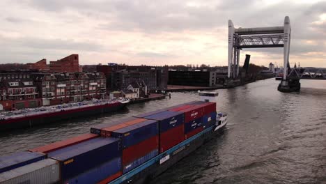 Aerial-Circle-Dolly-Around-Alphenaar-Cargo-Ship-Leaving-Raised-Spoorbrug-Railway-Bridge-In-Background